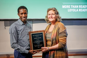 man and woman in front of screen holding a plaque